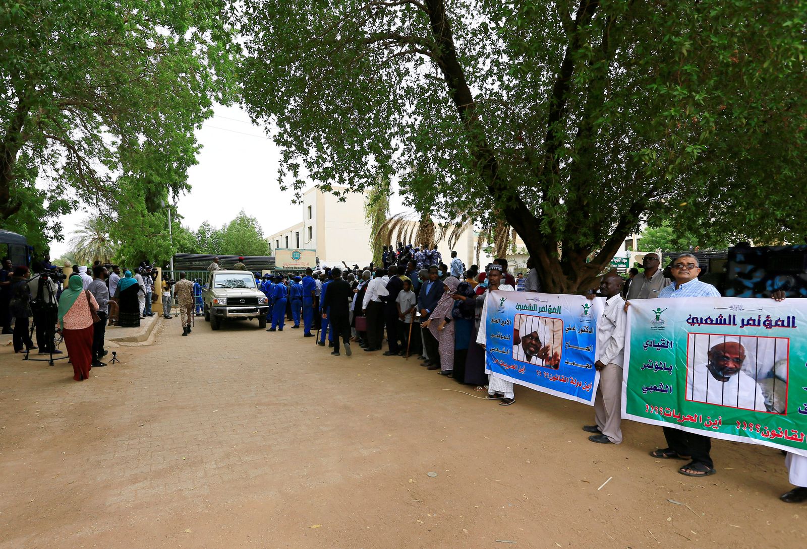 مدنيون سودانيون يتجمعون خارج المحكمة خلال المحاكمة الجديدة ضد الرئيس المخلوع عمر البشير وبعض حلفائه السابقين بتهمة قيادة انقلاب عسكري أدى إلى استبداد السلطة في عام 1989 في الخرطوم - REUTERS