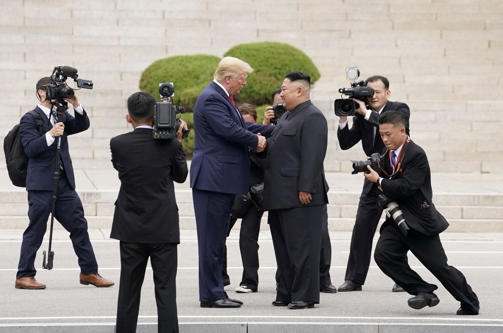 الزعيم الكوري الشمالي كيم جونغ أون والرئيس الأميركي دونالد ترمب خلال لقائهما في المنطقة المنزوعة السلاح بين الكوريتين - 30 يونيو 2019 - REUTERS