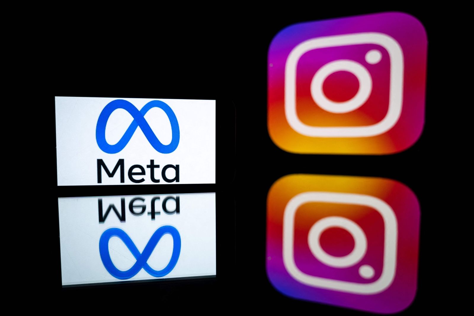 (FILES) This file illustration photo taken on January 12, 2023 in Toulouse, southwestern France, shows a smartphone and a computer screen displaying the logos of Instagram app and its parent company Meta. - Facebook and Instagram owner Meta will launch a paid subscription service allowing users to verify their accounts, among other features, CEO Mark Zuckerberg said on February 19, 2023. (Photo by Lionel BONAVENTURE / AFP)