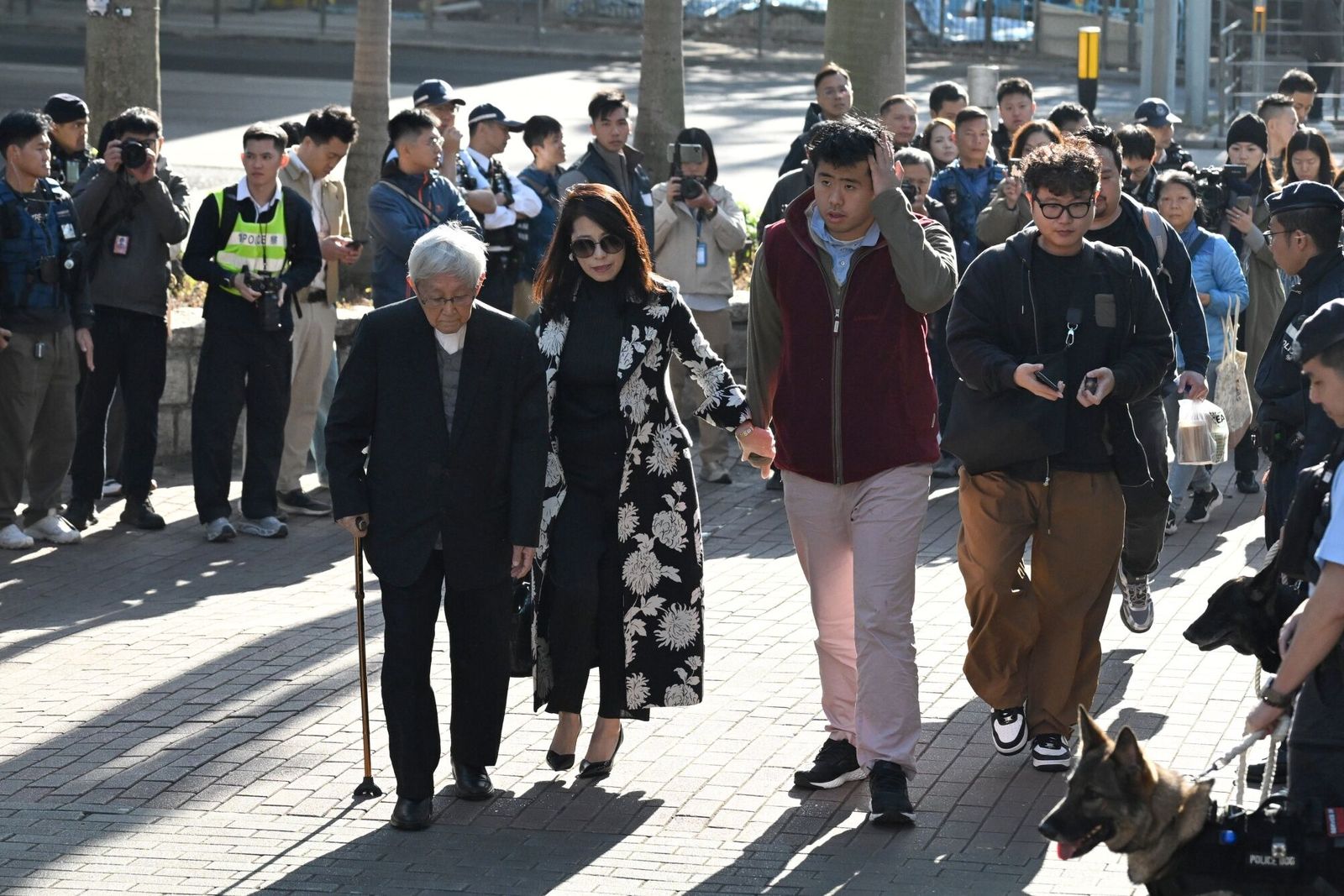 Teresa Lai, wife of former media mogul Jimmy Lai, center left, their son Lai Shun Yan, center right, and Joseph Zen, cardinal of the Holy Roman Church, left, arrive at the West Kowloon Court to hear the verdict in Lai�s national security trial in Hong Kong, China, on Monday, Dec. 15, 2025. Lai faces a verdict on Monday in a landmark national security trial, a decision that will help define the limits of free speech in the Chinese territory and potentially strain relations with the US and UK. Photographer: Billy H.C. Kwok/ Bloomberg