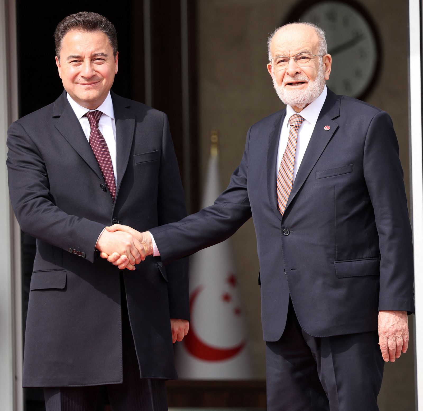 Ali Babacan Democracy and Progress (DEVA) (L) and the Chairman of the Felicity Party (SP) Temel Karamollaoglu (R) shake hands as they pose for the press before their meeting in Ankara on March 2, 2023. - The Republican People's Party (CHP), the Felicity Party (SP), the Democracy and Progress Party (DEVA), the Democratic Party (DP), Iyi (Good) Party and the Future Party have formed an alliance against the ruling Justice and Development Party for the 2023 Turkish general election. (Photo by Adem ALTAN / AFP) - AFP