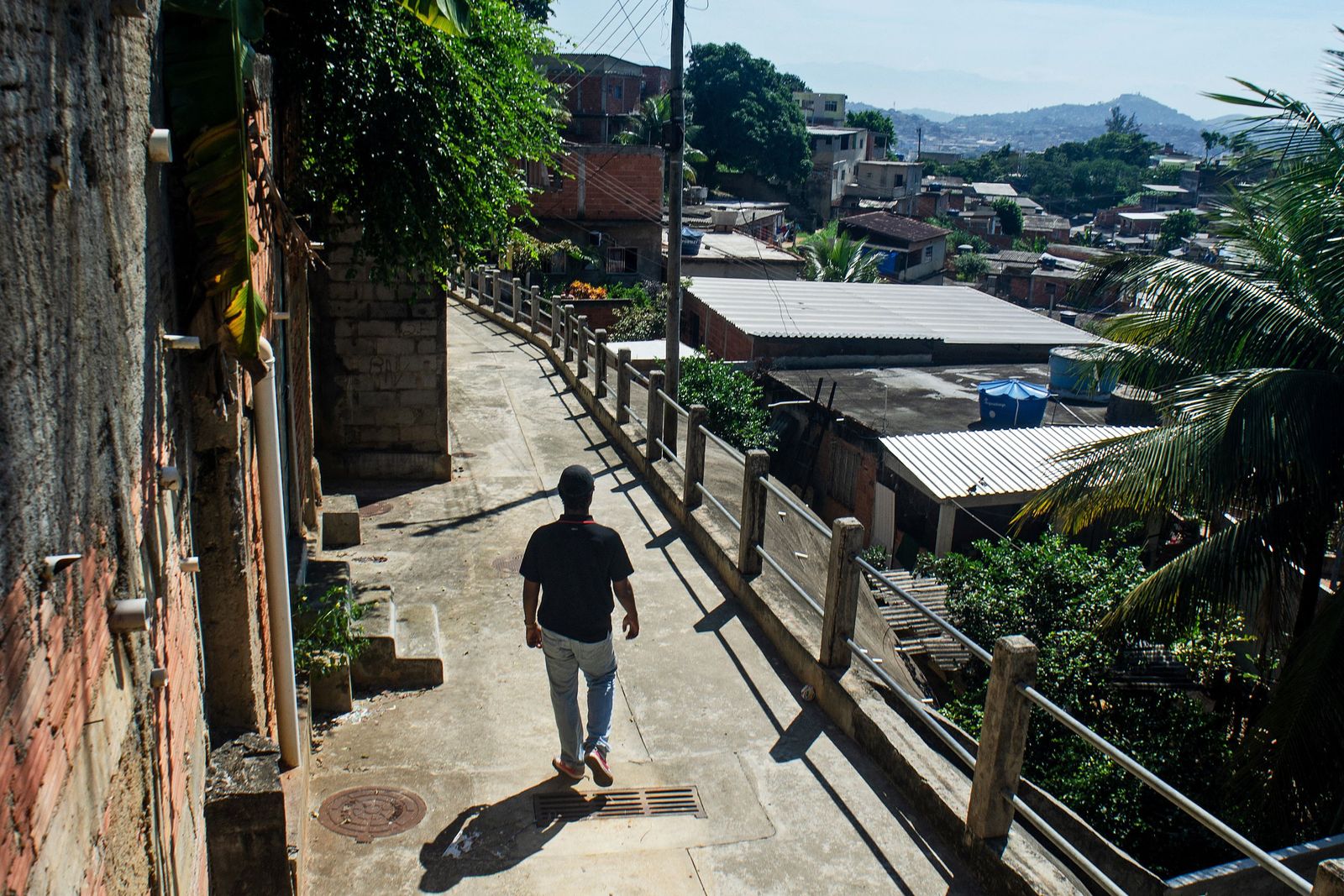 Brazilian artist Johny Alexandre Gomes, known as Jota, 22, walks on a street of the Chapadao favela in Rio de Janeiro, Brazil on April 13, 2023. - A new generation of young black artists from Rio de Janeiro's poor neighborhoods is gaining prominence at contemporary art fairs and prestigious museums. (Photo by TERCIO TEIXEIRA / AFP) - AFP