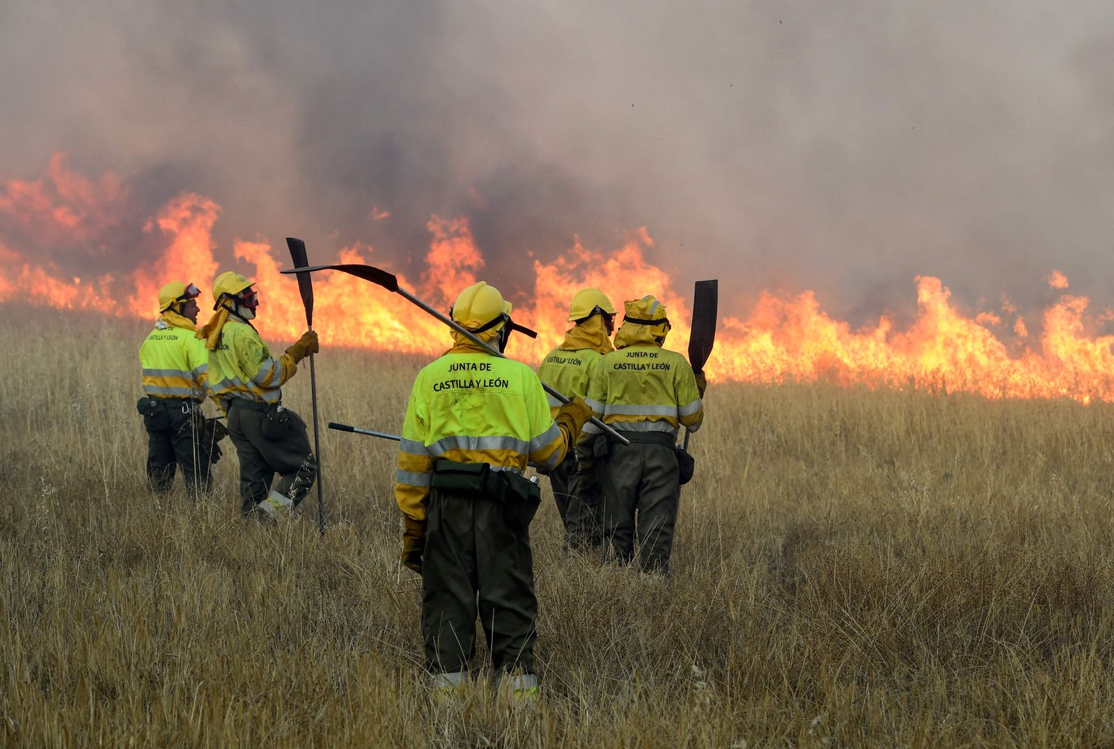 Firefighters stand guard as they look at fire in the village of Tabara, near Zamora, northwest Spain, on July 18, 2022. - Emergency services battled several wildfires as Spain remained in the grip of an exceptional heatwave that has seen temperatures reach 43 degrees Celsius (109 degrees Farenheit). (Photo by MIGUEL RIOPA / AFP) - AFP