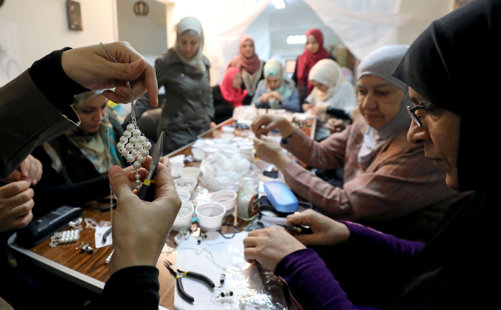 Syrian refugees crafts necklaces at a United Nations Population Fund, safe space for refugee women and girls residing in Cairo - REUTERS