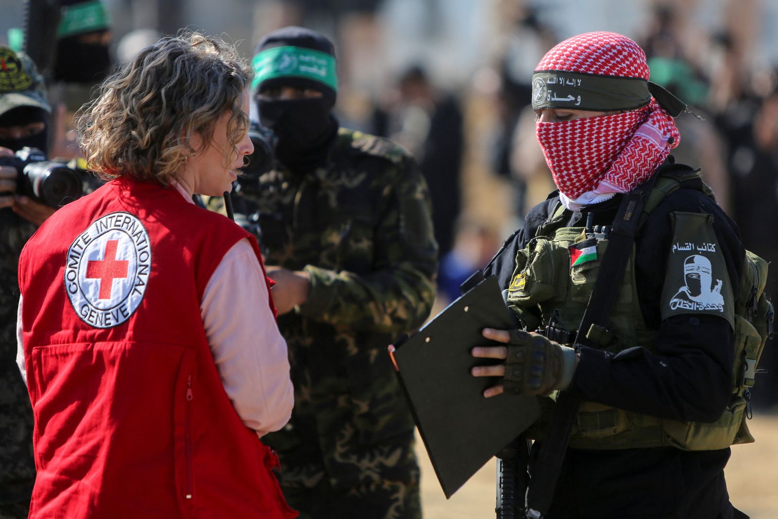 A Palestinian Hamas militant speaks with a member of the Red Cross before the release of hostages held in Gaza since the deadly October 7, 2023 attack, as part of a ceasefire and a hostages-prisoners swap deal between Hamas and Israel in Khan Younis, in the southern Gaza Strip, February 15, 2025. REUTERS/Hatem Khaled