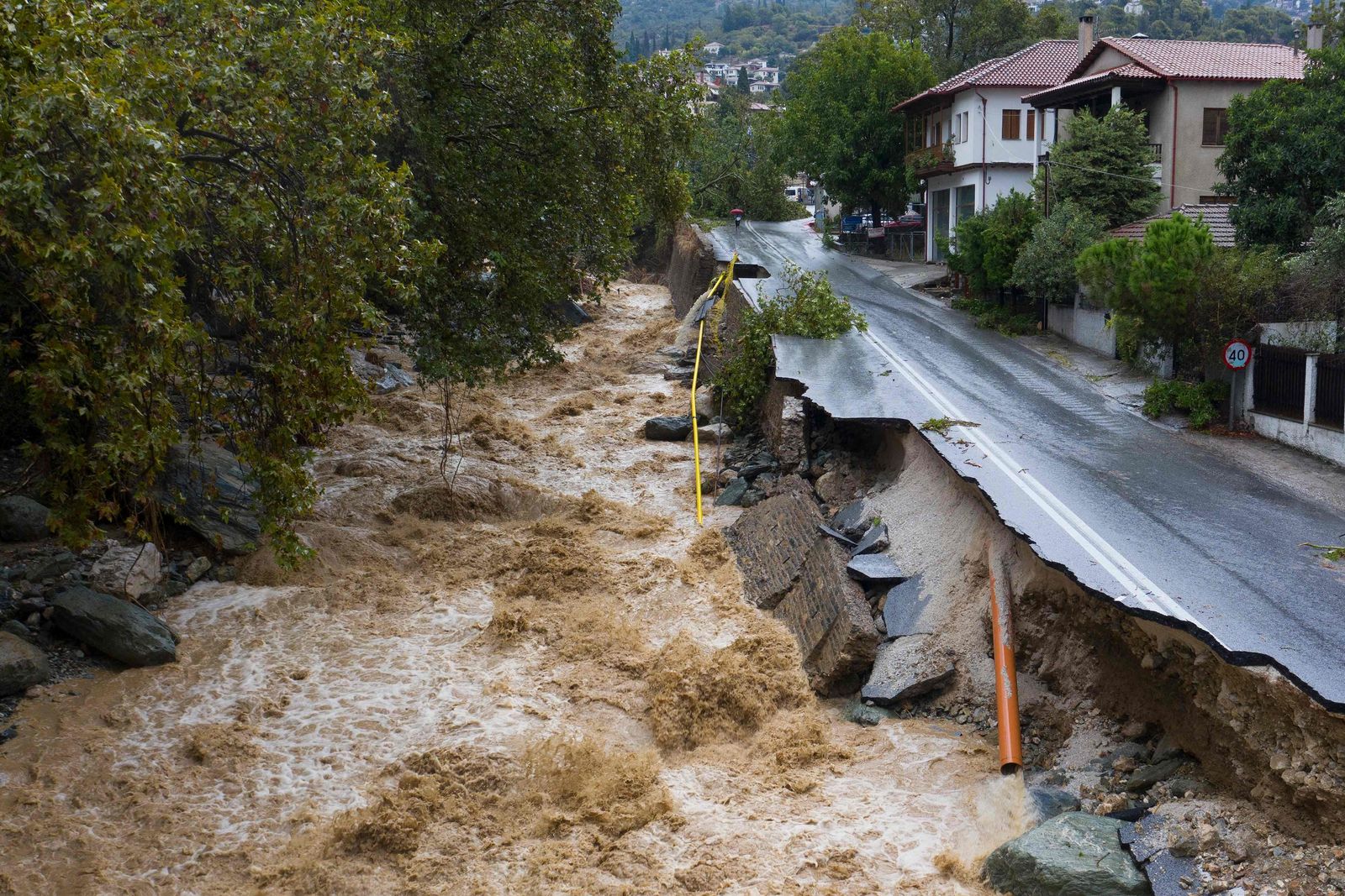 An aerial view taken on September 6, 2023 shows a partially destroyed road in a flooded area in the city of Volos, central Greece. The regional capital Volos has seen 200 millimetres (about eight inches) of rain, while 600 mm have fallen in the neighbouring village of Zagora, according to the National Meteorological Service (EMY). At least one person died in eastern Greece after torrential rains hit the country, already ravaged for weeks by devastating wildfires, authorities said on September 5, 2023. (Photo by STRINGER / Eurokinissi / AFP) - AFP