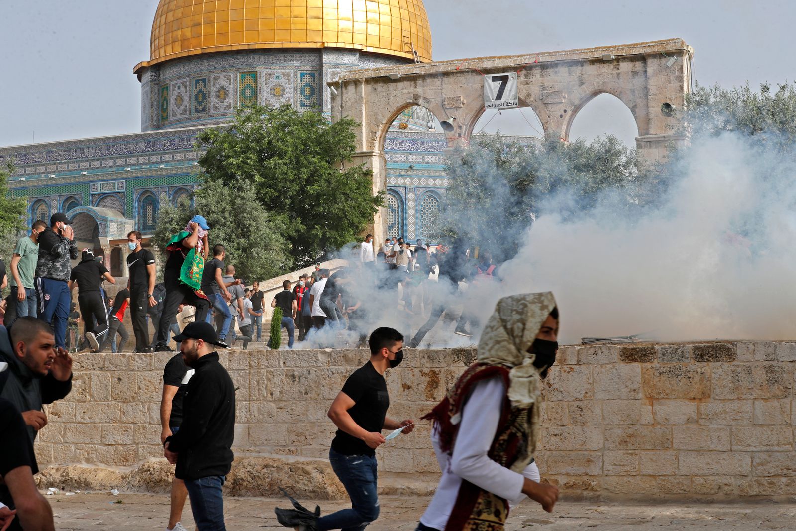 فلسطينيون يسعون للاحتماء من الغاز المسيل للدموع الذي أطلقته القوات الإسرائيلية قرب المسجد الأقصى في القدس - 10 مايو 2021 - AFP