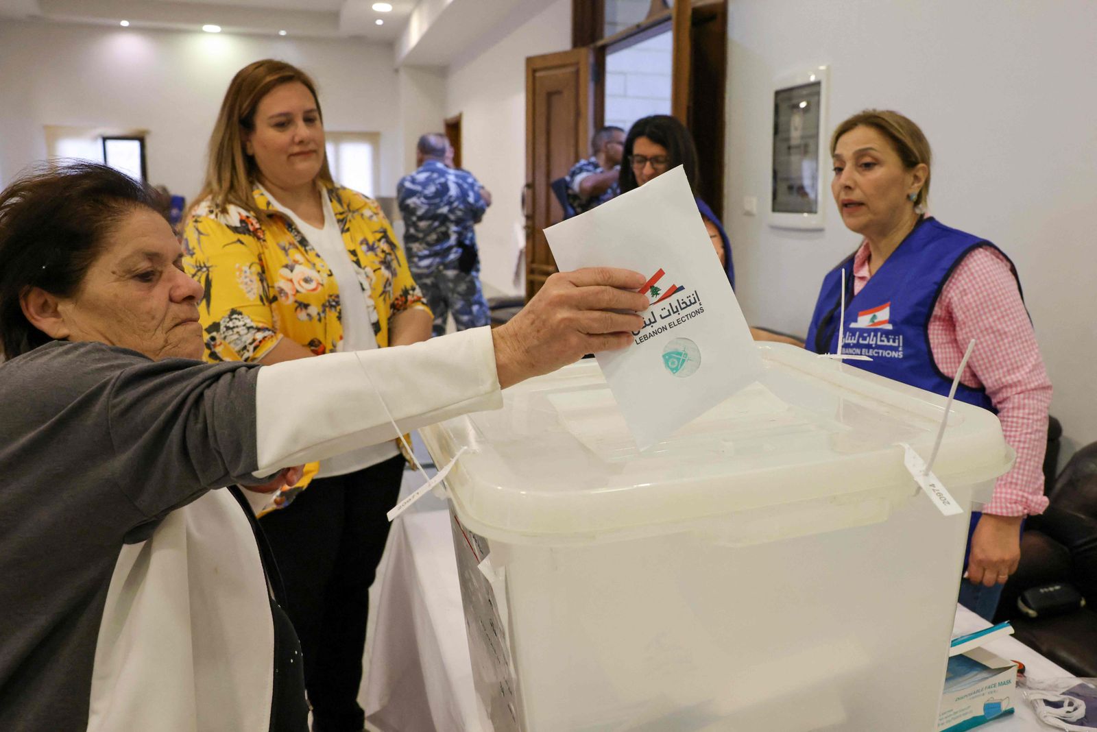 A voter casts her ballot in the parliamentary election at a polling station near the Lebanese coastal city of Byblos (Jbeil), north of the capital Beirut, on May 15, 2022. - Lebanon voted in its first election since multiple crises dragged it to the brink of failed statehood, with the ruling elite expected to comfortably weather public anger. The parliamentary election is a first test for opposition movements spawned by an unprecedented anti-establishment uprising in 2019 that briefly raised hopes of regime change in Lebanon. (Photo by Joseph EID / AFP) - AFP