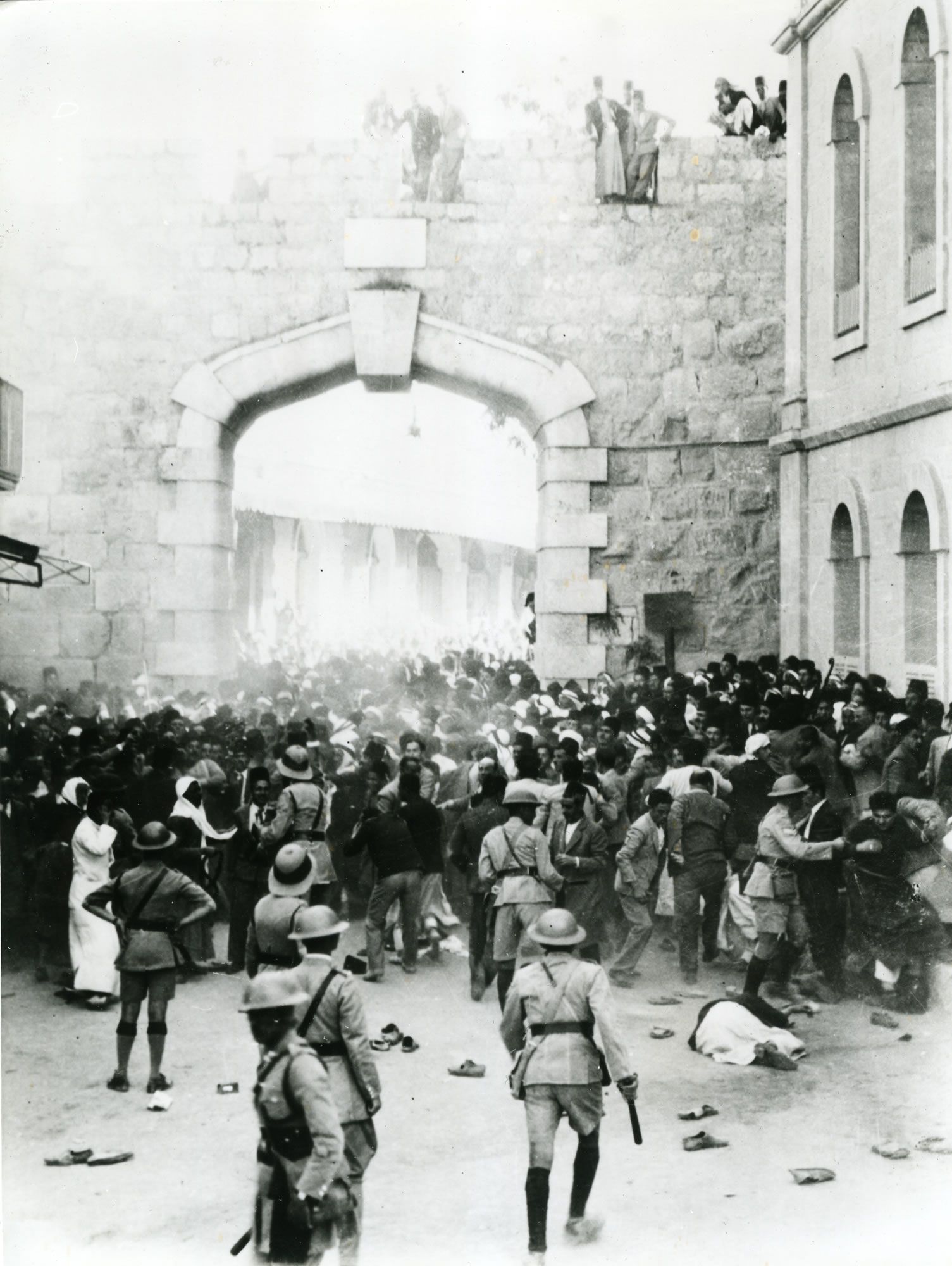   الباب الجديد، القدس، 13 أكتوبر 1933، في أعقاب مظاهرة فلسطينية احتجاجاً على الهجرة الجماعية اليهودية إلى فلسطين. الشرطة تطوّق المتظاهرين وتمنع تقدّمهم. - www.palquest.org