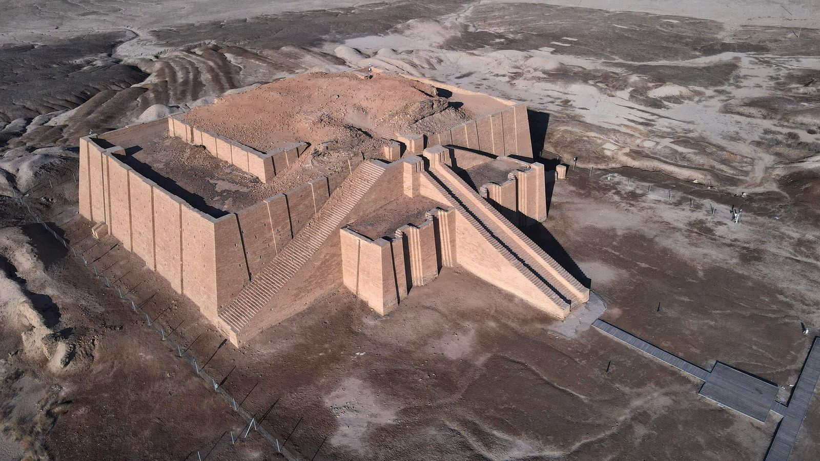 An aerial picture taken on February 13, 2022 shows the Great Ziggurat temple (back) in the ancient city of Ur in Iraq's southern province of Dhi Qar near the city of Nasiriyah. - Between the 2003 US invasion, the bloody sectarian conflict that followed, then the rise to power of the Islamic State (IS) group, Iraq for years made the headlines above all for news of conflict and violence. Today, several Western countries still formally advise against travelling to Iraq, but Baghdad seeks to revive its tourism sector, taking up many challenges. (Photo by Asaad NIAZI / AFP) - AFP