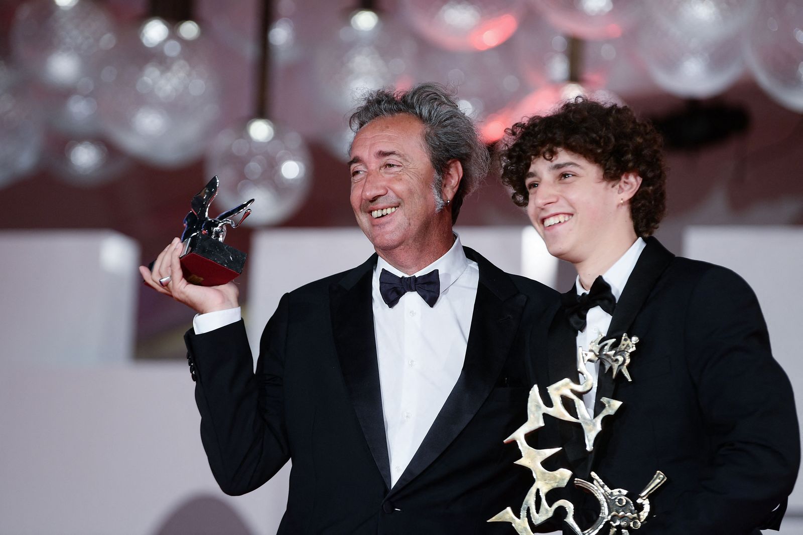 Italian director Paolo Sorrentino (L) poses with the Silver Lion - Grand Jury Prize he received for 