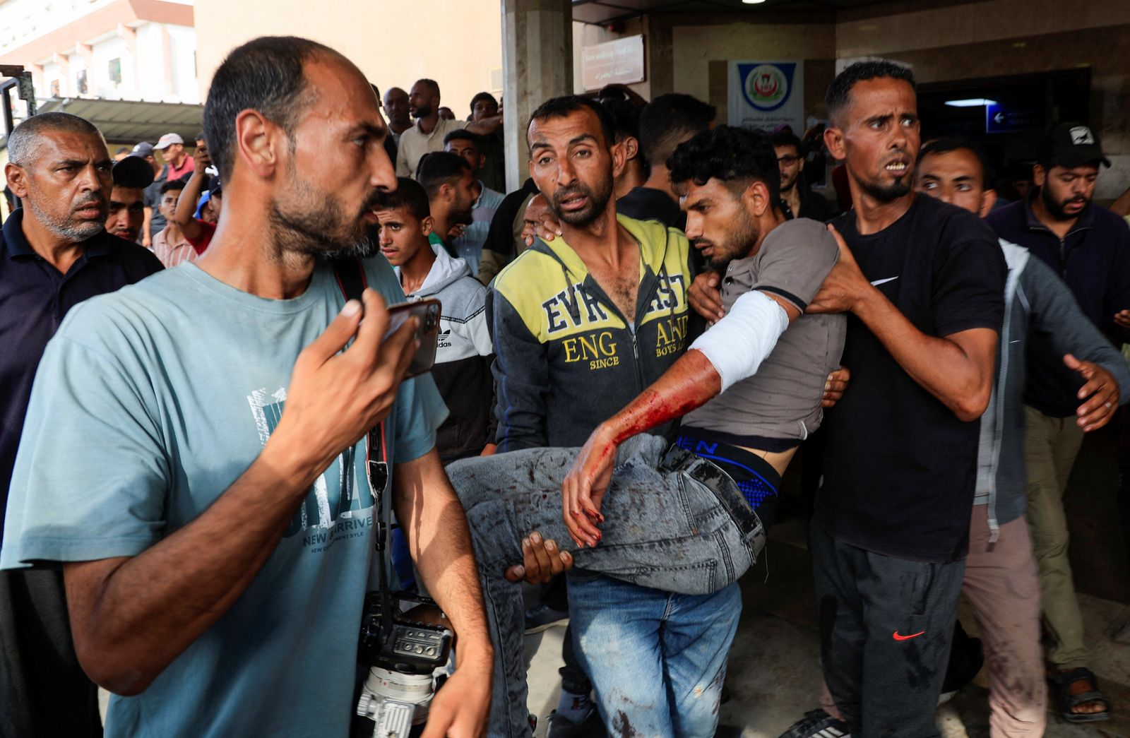 A Palestinian carries a man who was wounded in an Israeli strike while waiting for aid, according to the Gaza Health Ministry, at Nasser hospital, in Khan Younis, southern Gaza Strip, June 17, 2025. REUTERS/Hatem Khaled