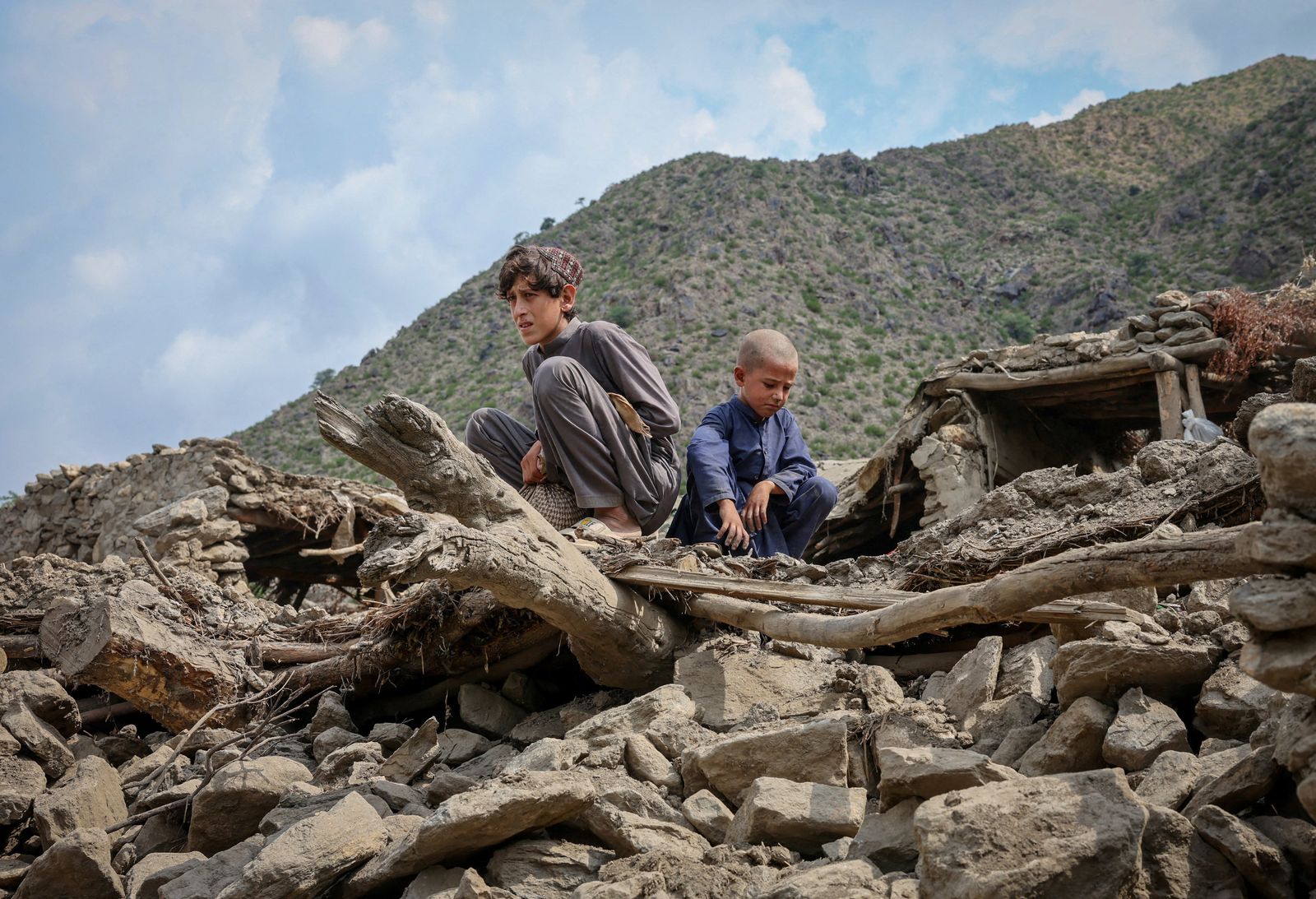 Afghan boys sit on the rubble of a house following a deadly magnitude-6 earthquake that struck Afghanistan on Sunday, at Lulam village, in Nurgal district, Kunar province, Afghanistan, September 3, 2025. REUTERS/Sayed Hassib     TPX IMAGES OF THE DAY