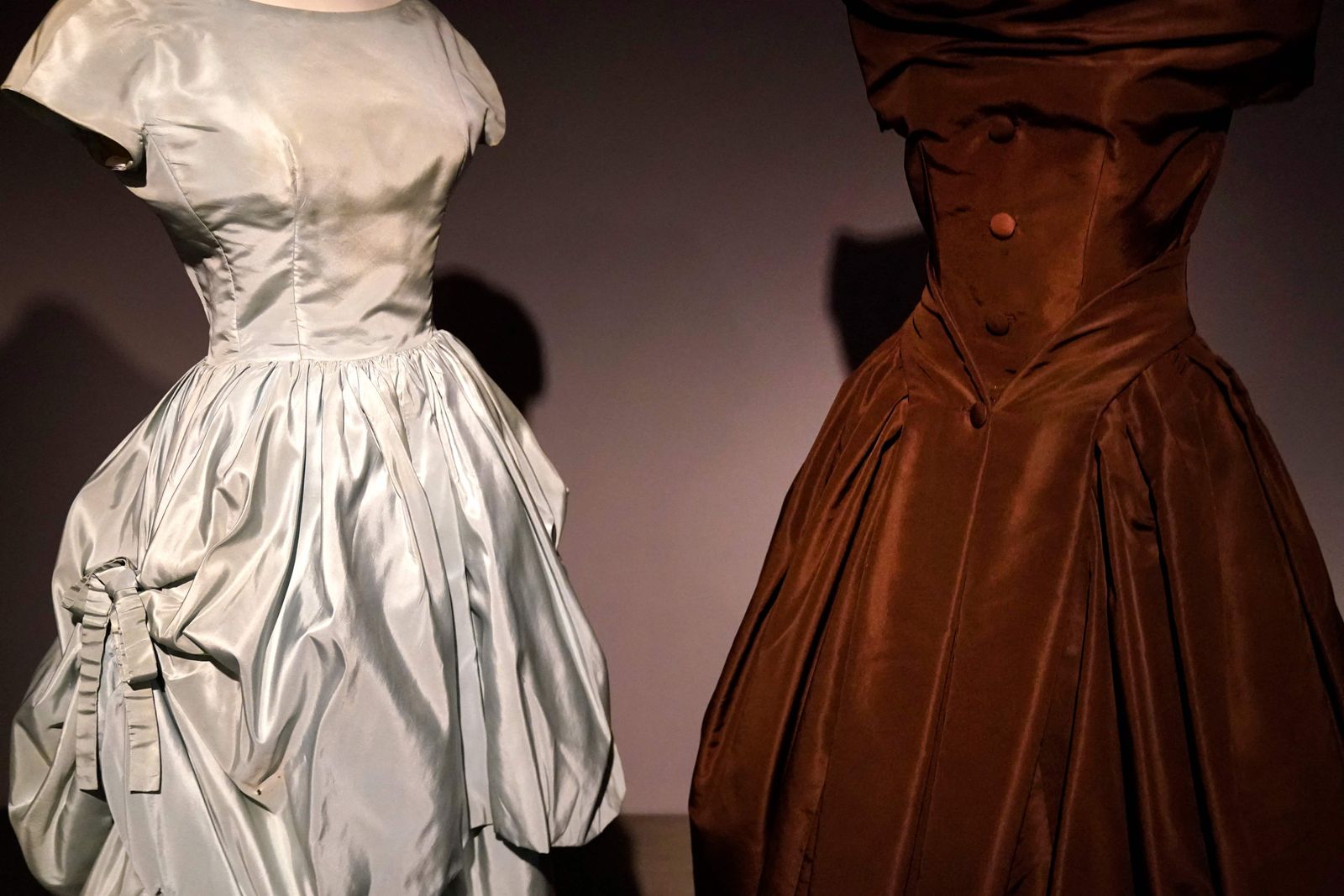 A Christian Dior (R), brown silk taffeta cocktail dress and Cristobal Balenciaga evening dress on display during 