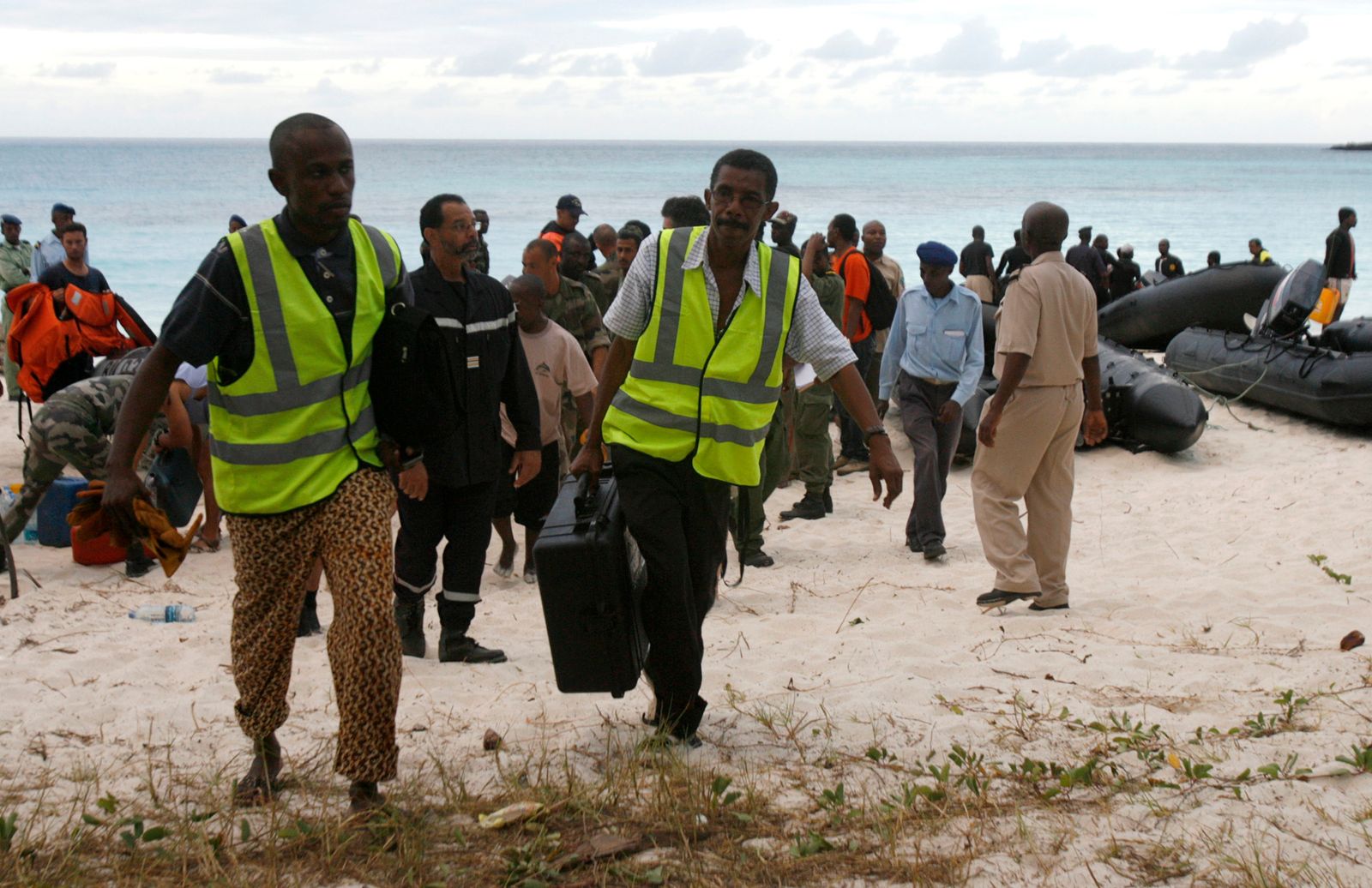 مسؤولون في الطيران المدني في جزر القمر يحملون معدات من زورق سريع بعد مهمة بحث عن الطائرة اليمنية المفقودة A310-300، جزر القمر. 5 يوليو 2009 - REUTERS