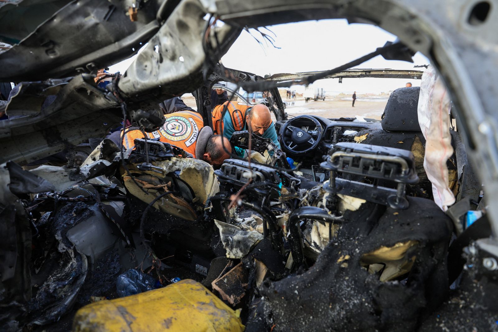 مسعفون يفحصون السيارة المتضررة جراء الغارة الإسرائيلية على مدينة غزة والتي استهدفت القيادي رائد سعد، 13 ديسمبر 2025 - REUTERS