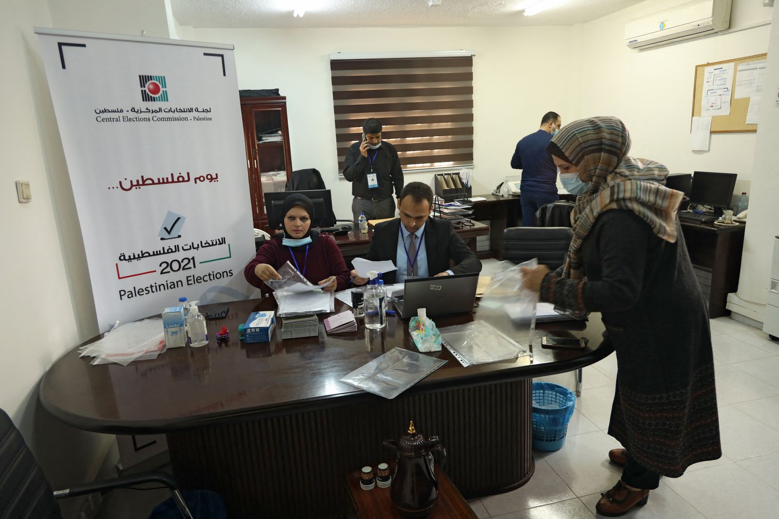 موظفو لجنة الانتخابات المركزية يعدون الوثائق في مكتب الهيئة بمدينة غزة، 20 مارس 2021 - AFP