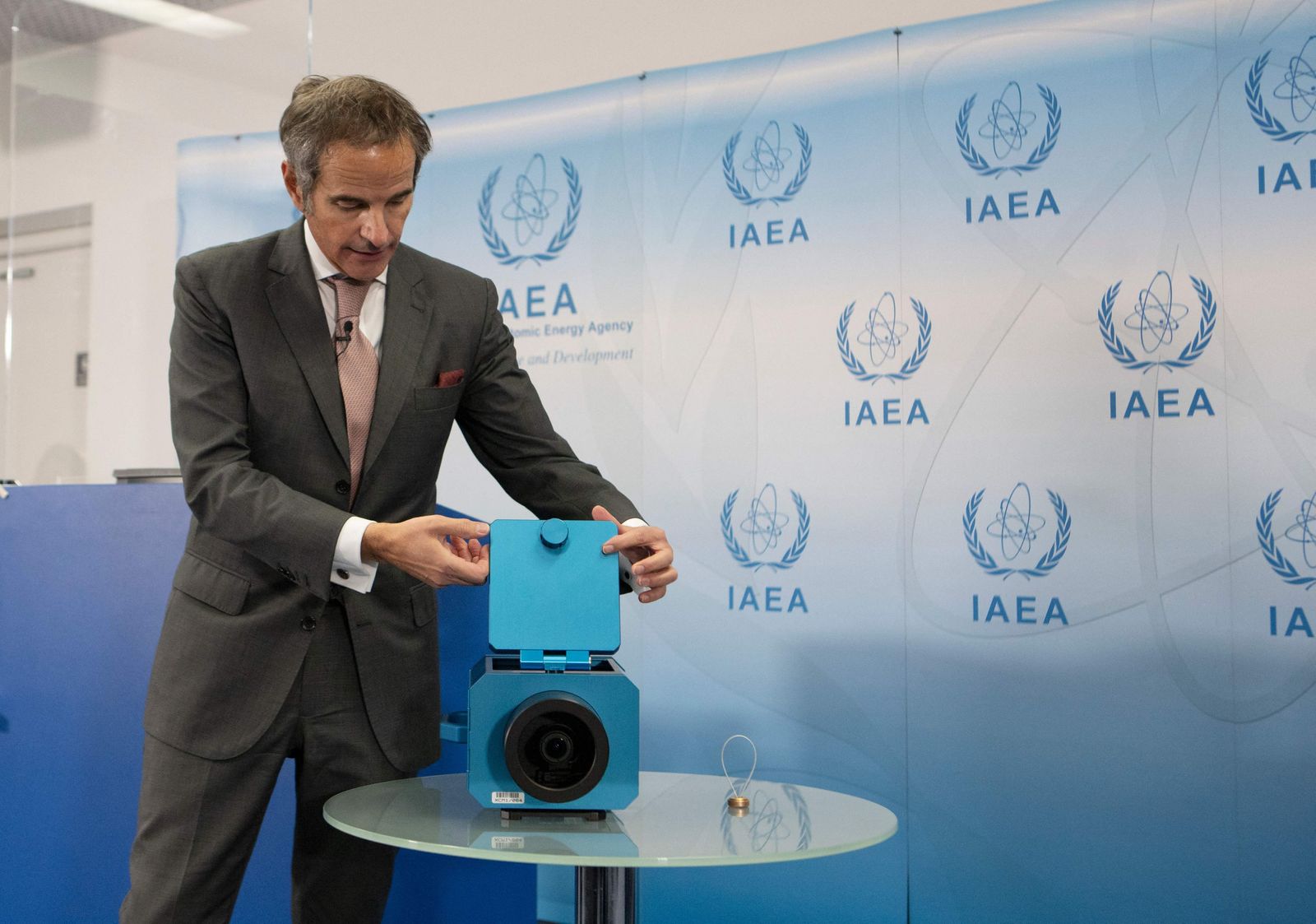 المدير العام لوكالة الطاقة الذرية رفاييل جروسي يعرض كاميرات المراقبة التي تستخدمها الوكالة في المنشآت النووية الإيرانية، خلال مؤتمر صحفي في جنيف. 17 ديسمبر 2021. - AFP