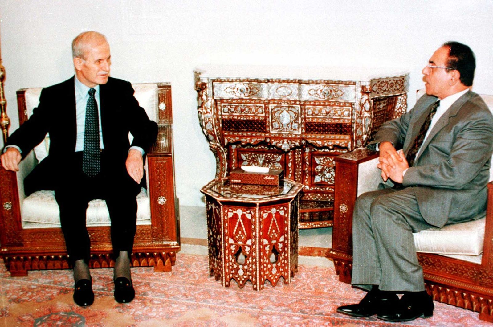 الرئيس السوري السابق حافظ الأسد (إلى اليسار) يتحدث في دمشق مع وزير الخارجية العراقي السابق محمد سعيد الصحاف الذي ينقل رسالة إلى الأسد من الرئيس العراقي صدام حسين، 10 فبراير 1998 - X00561
