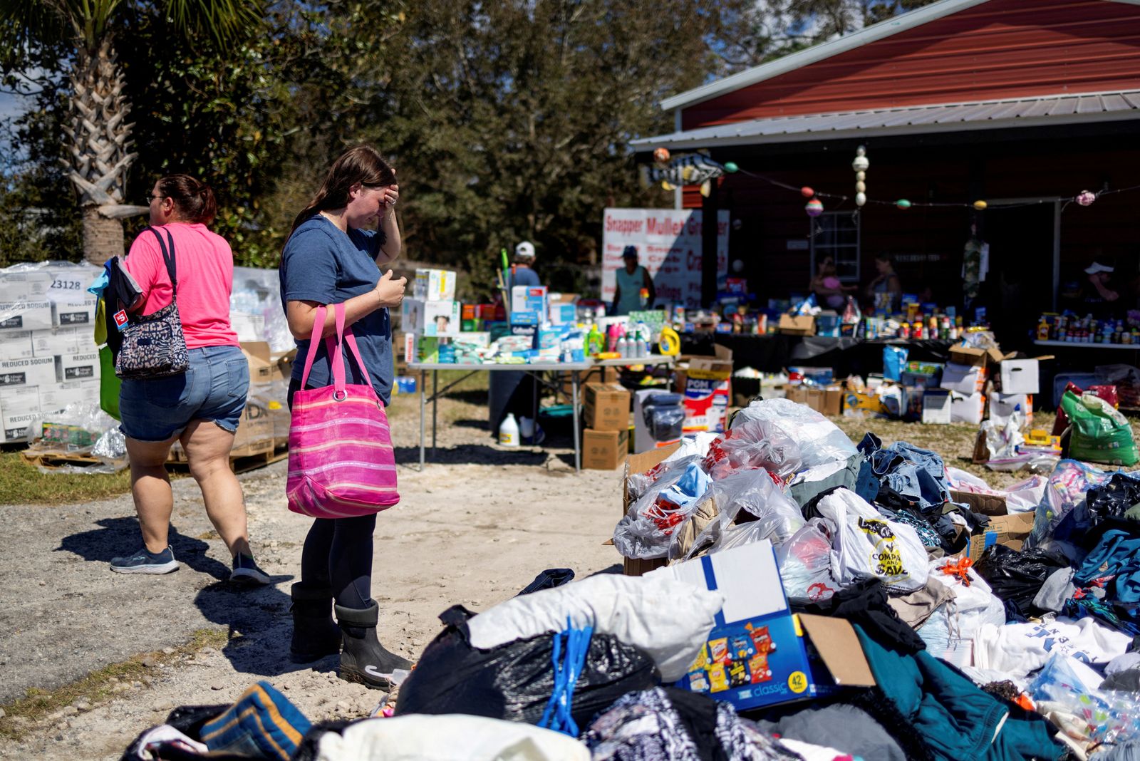 Maddie Hackney, who lost everything to the hurricane, pauses while looking for clothing at a donation center organized by Janalea and Garrett England, at their business Steinhatchee Fish Company in the wake of Hurricane Helene in Steinhatchee, Florida, U.S., September 29, 2024.   REUTERS/Kathleen Flynn     TPX IMAGES OF THE DAY