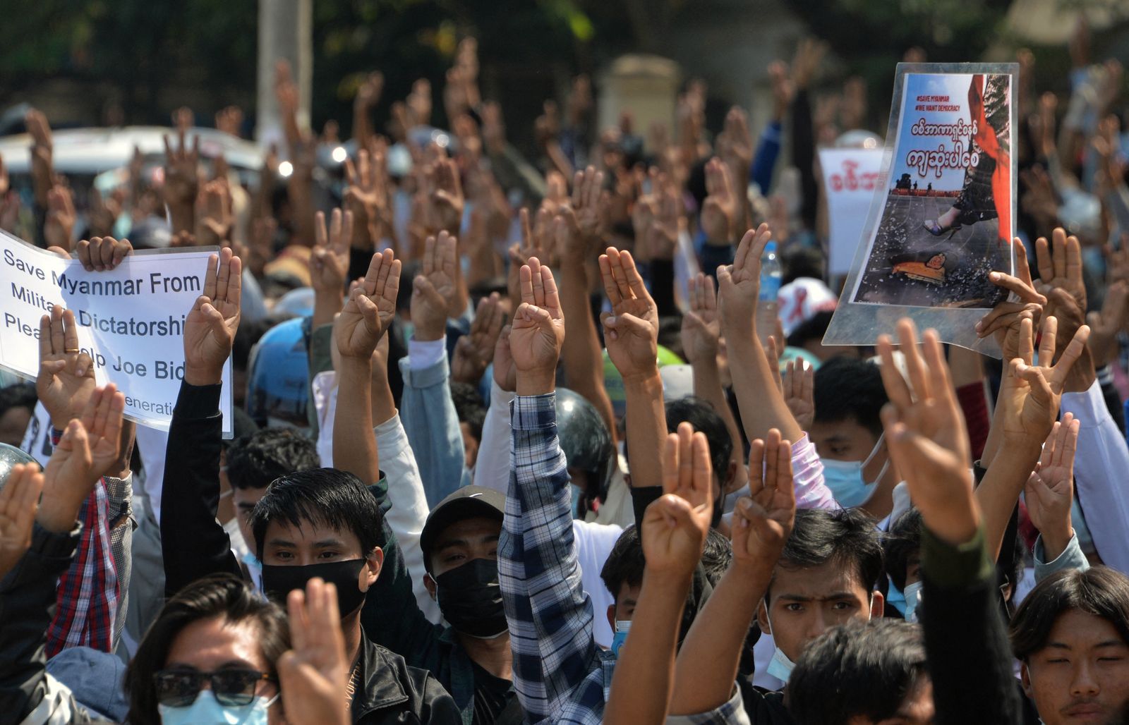 متظاهرون يرفعون شعار المقاومة بأصابعهم الثلاثة خلال مظاهرة ضد الانقلاب العسكري في مدينة نايبيداو - 12 فبراير 2021  - AFP