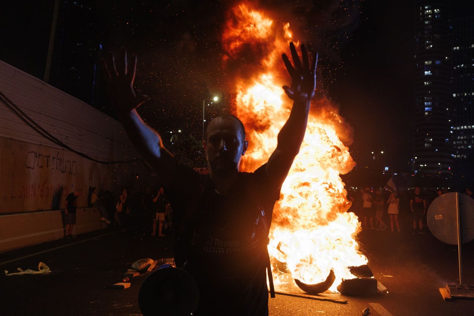 An Israeli stands in front of burning debris while protesting for hostage release and against the government during a demonstration in Tel Aviv, Israel, on Sunday, Sept. 1, 2024. Hundreds of thousands of Israelis demonstrated in cities around the nation on Sunday � in what appeared to be the largest protests since the Oct. 7 attacks � after the bodies of six hostages were found in a tunnel in the Gaza Strip. Photographer: Kobi Wolf/Bloomberg