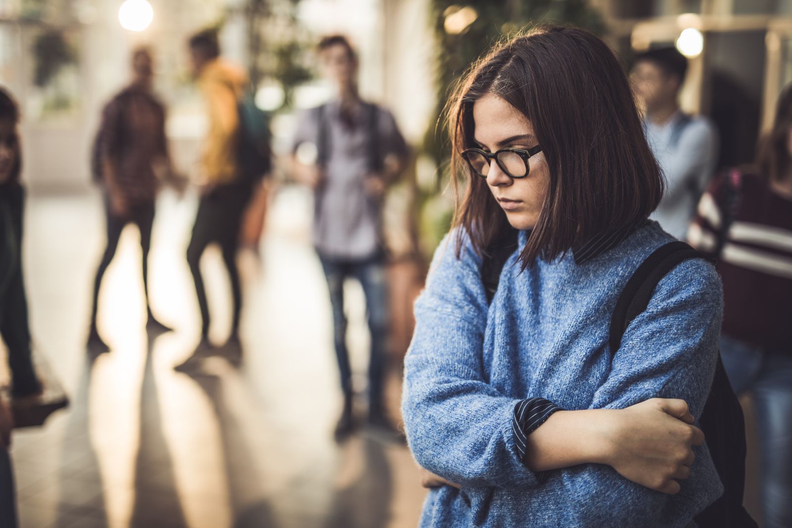Sad high school student feeling lonely in a hallway. - Getty Images
