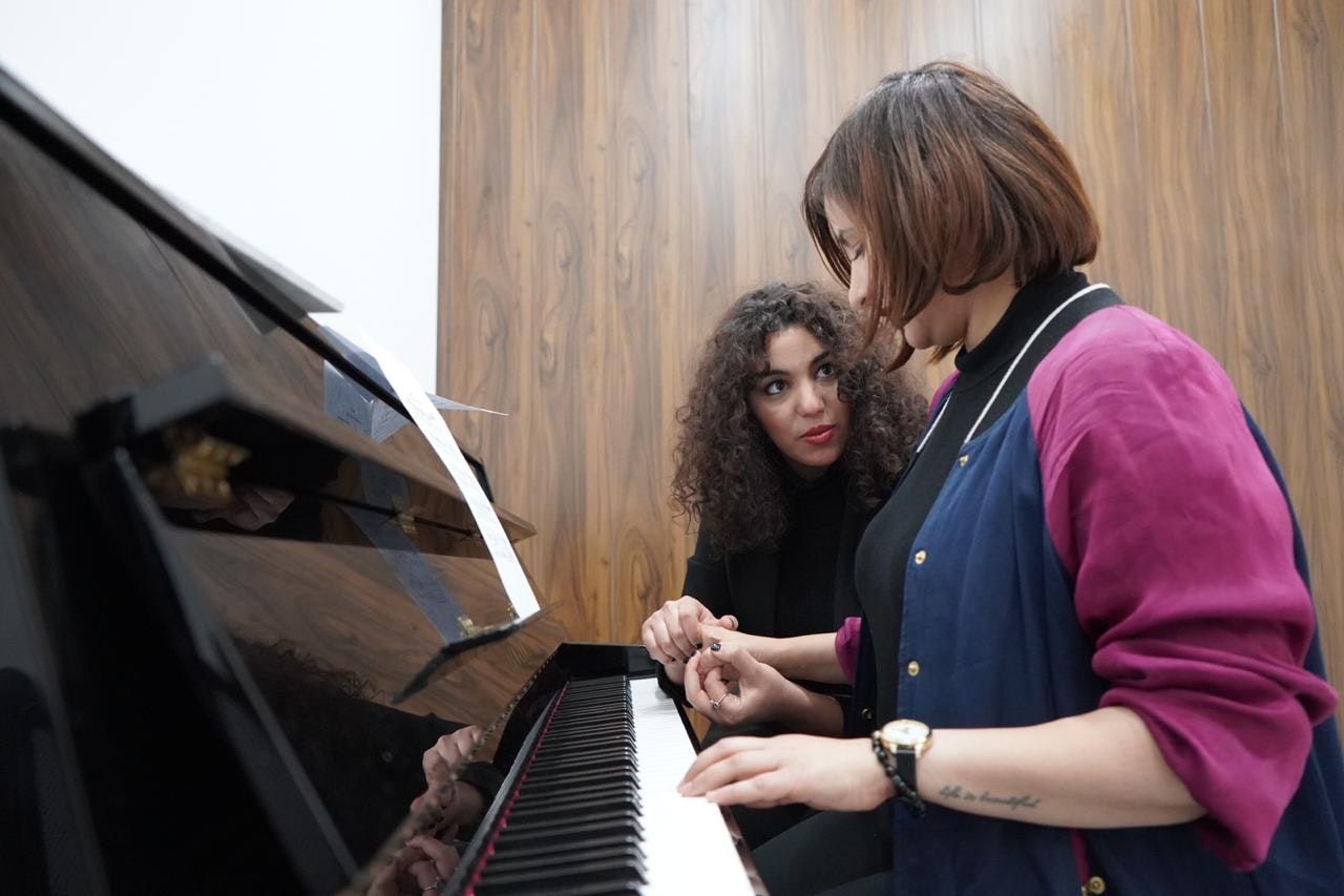 مدربة بيانو مع إحدى المتدربات - الدكتور أيمن تيسير مدير معهد بيت الموسيقى 