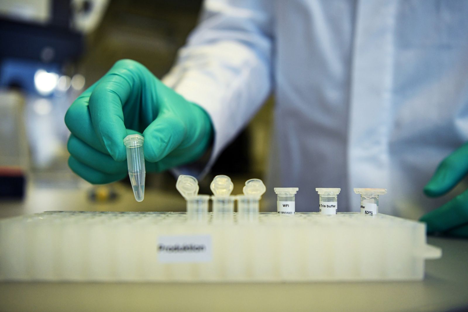 موظف من شركة الأدوية الكيماوية الألمانية كيورفاك، يوضح سير العمل البحثي على لقاح لمرض كورونا بمختبر في توبنغن - REUTERS