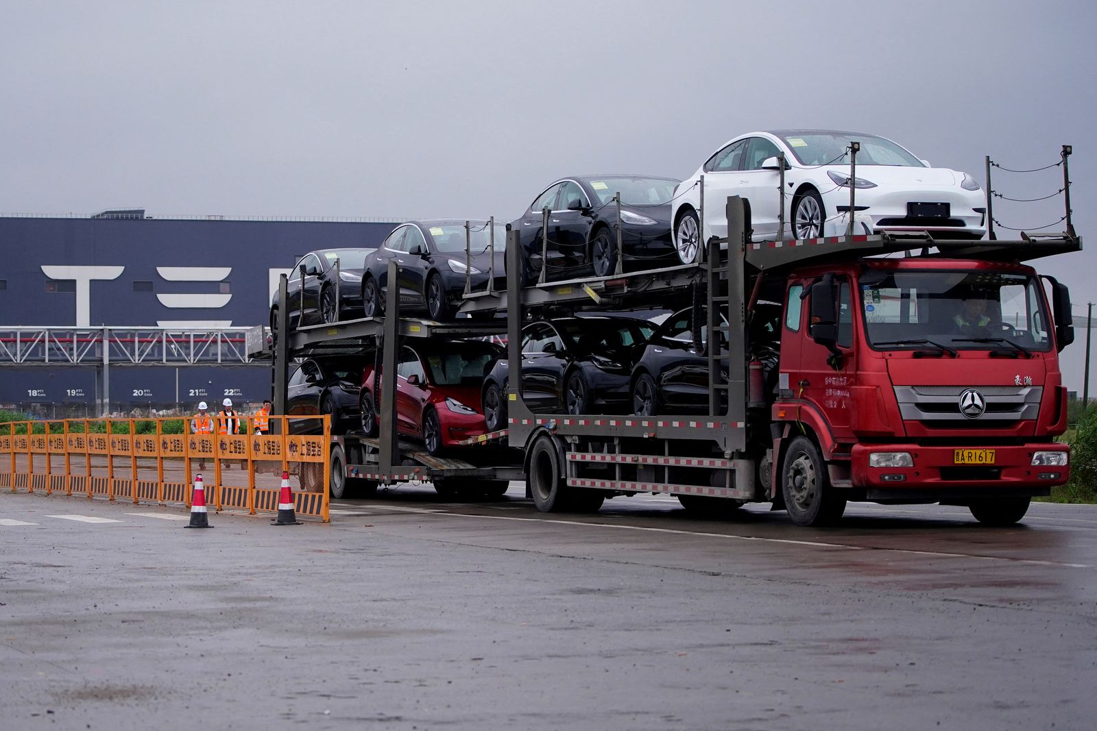 FILE PHOTO: A truck transports new Tesla cars at its factory in Shanghai - REUTERS