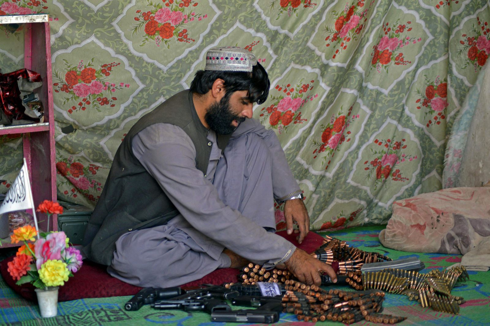 An Afghan vendor prepares ammunition to display for sale while waiting for customers in his shop at a market in Panjwai district of Kandahar province on September 4, 2021. (Photo by JAVED TANVEER / AFP) - AFP