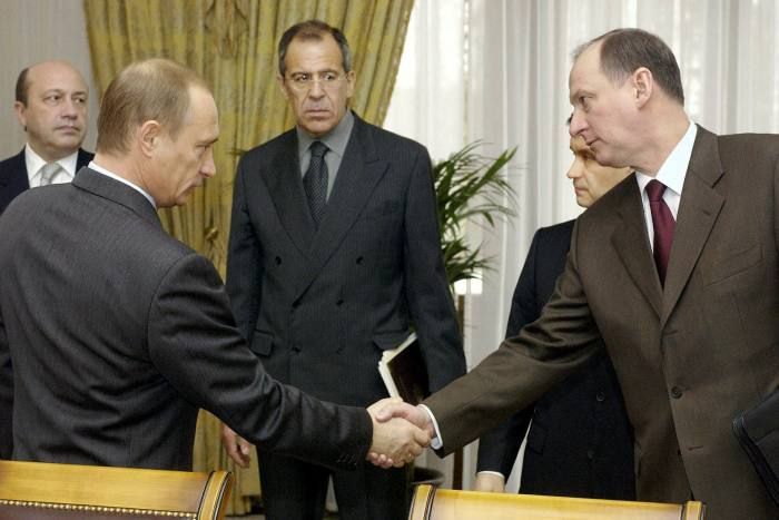 الرئيس الروسي فلاديمير بوتين يصافح نيكولاي باتروشيف الرئيس الحالي لمجلس الأمن الروسي، 2004 - Tass/AFP/Getty