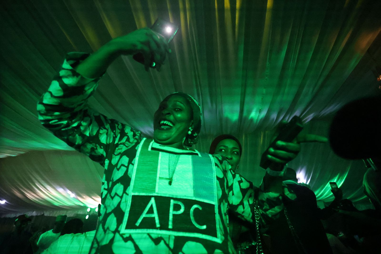 Supporters of the Nigerian presidential candidate Bola Tinubu, of the ruling All Progressive Congress (APC), celebrate in Abuja on March 1, 2023 at his campaign headquarters. - Ruling party candidate Bola Tinubu has won the most votes in Nigeria's highly disputed weekend election, according to final results on Wednesday, almost certainly securing him the presidency of Africa's most populous democracy. The Independent National Electoral Commission, or INEC, must still confirm whether Tinubu secured 25 percent of votes in two-thirds of Nigeria's 36 states and capital, a threshold he must hit to be confirmed president. (Photo by Kola SULAIMON / AFP) - AFP