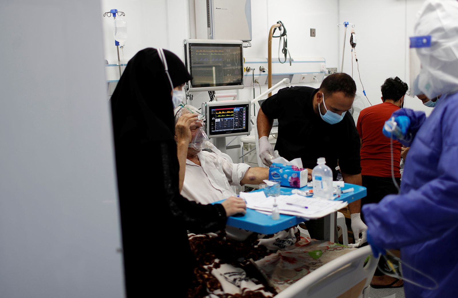 أحد أفراد الأطقم الطبية العراقية يقدم الدعم الطبي لأحد المرضى  - REUTERS