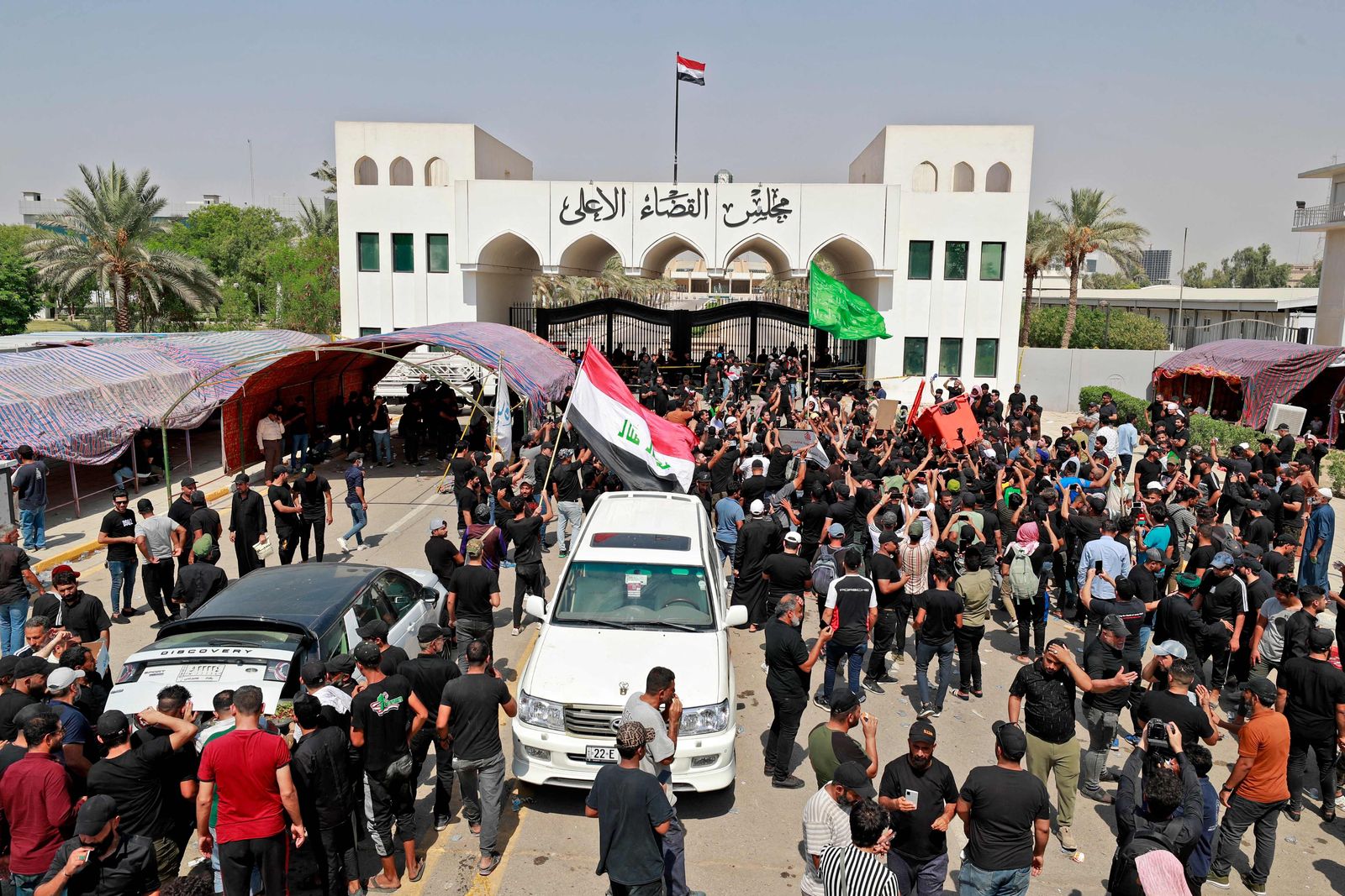 Supporters of Iraqi Muslim Shiite cleric Moqtada Sadr gather outside the headquarters of the Supreme Judicial Council, Iraq's highest judicial body, in the capital Baghdad on August 23, 2022. - The Sadrists, who have already been camping outside parliament for the past three weeks, pitched tents outside the gates of the body's Baghdad headquarters with placards demanding the dissolution of parliament and new elections. (Photo by Ahmad Al-Rubaye / AFP) - AFP