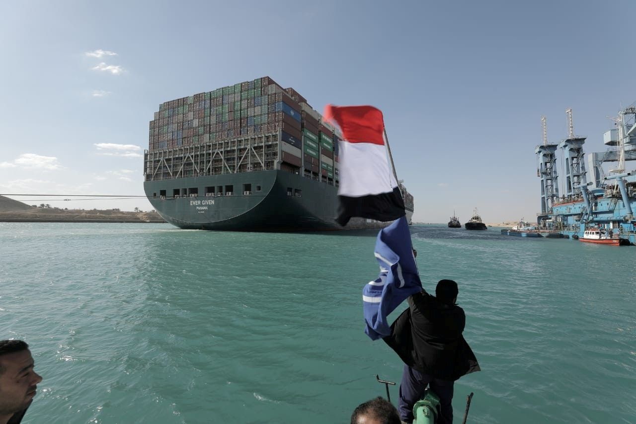 رجل يلوح بالعلم المصري بعد تعويم سفينة إيفر غيفن في قناة السويس - 29 مارس 2021 - VIA REUTERS