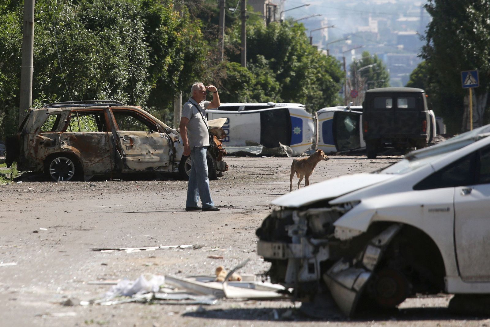 TOPSHOT - A man stands by a barricade made with destroyed police cars in Lysychansk on June 21, 2022, as Ukraine says Russian shelling has caused 
