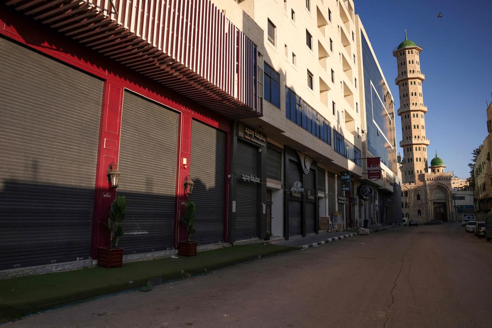 A picture shows shuttered shops during a general strike in solidarity with Gaza, in the occupied West Bank city of Hebron, on December 11, 2023, amid continuing battles between Israel and the militant group Hamas. (Photo by HAZEM BADER / AFP)