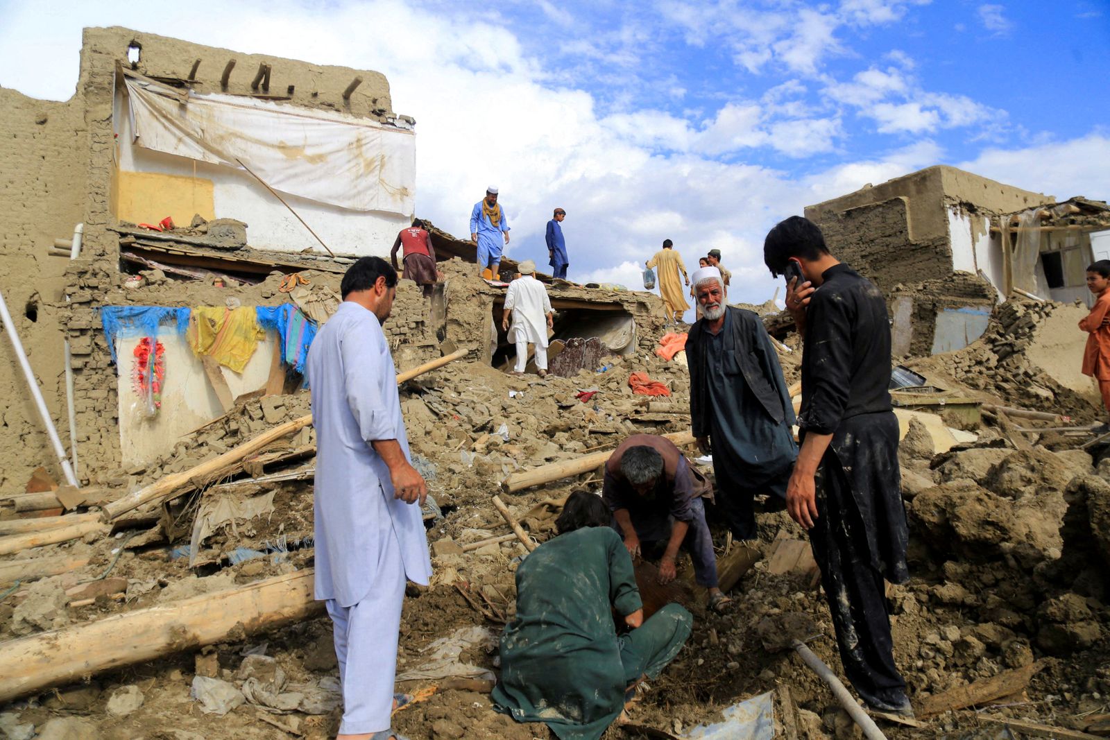 People clean up their damaged homes after the heavy flood in the Khushi district of Logar - REUTERS