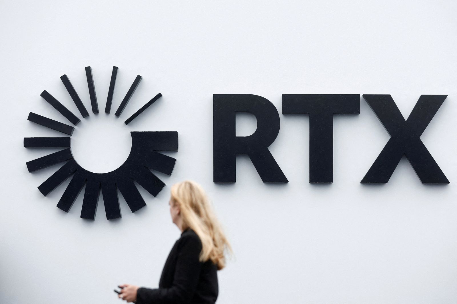 FILE PHOTO: Visitor passes the Raytheon Technologies Corporation (RTX) logo at the 54th International Paris Air Show at Le Bourget Airport near Paris, France, June 22, 2023. REUTERS/Benoit Tessier/File Photo
