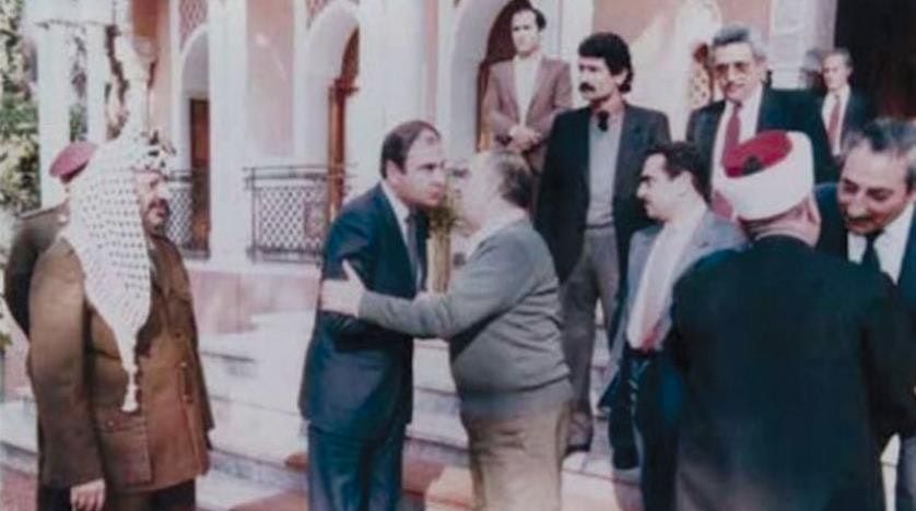  رئيس الوزراء الأردني الأسبق طاهر المصري يعانق أبو إياد، بينما يقف ياسر عرفات إلى جانبهما. - الشرق الأوسط
