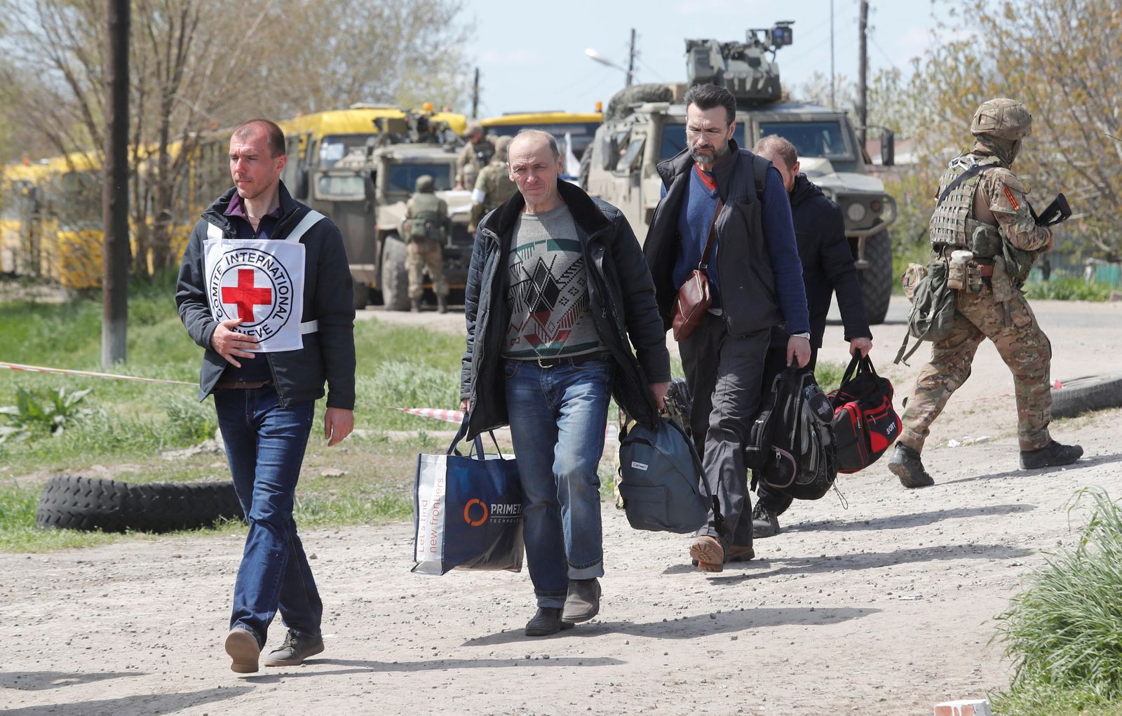 Civilians who left the area near Azovstal steel plant in Mariupol walk at a temporary accommodation centre in Bezimenne - REUTERS