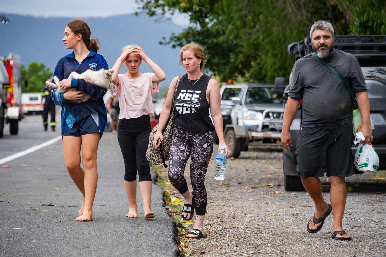 People arrive in Cairns on December 18, 2023, after being evacuated from their homes in the northern suburbs. Flash floods swamped northeastern Australia on December 18, with raging waters severing roads and flushing crocodiles into towns. (Photo by Brian CASSEY / AFP)