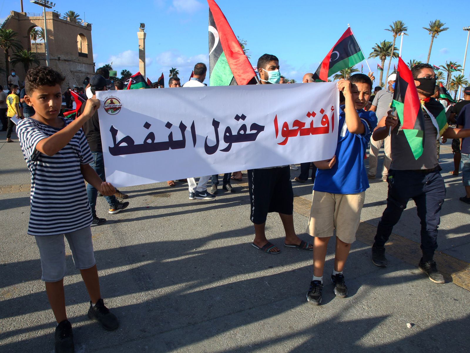 ليبيون يحملون لافتة كتب عليها 