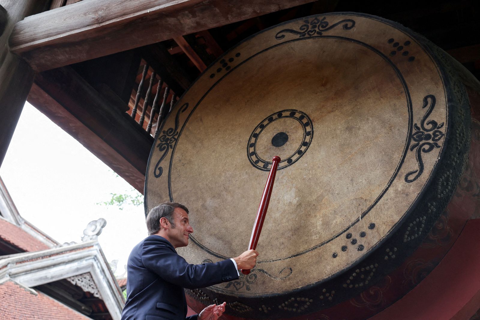 French President Emmanuel Macron beats a drum, marking the beginning of a new day, at Van Mieu during a luncheon with Vietnam's Communist Party General Secretary To Lam (not pictured), during Macron's first official trip to the country, in Hanoi, Vietnam May 26, 2025. REUTERS/Chalinee Thirasupa/Pool     TPX IMAGES OF THE DAY