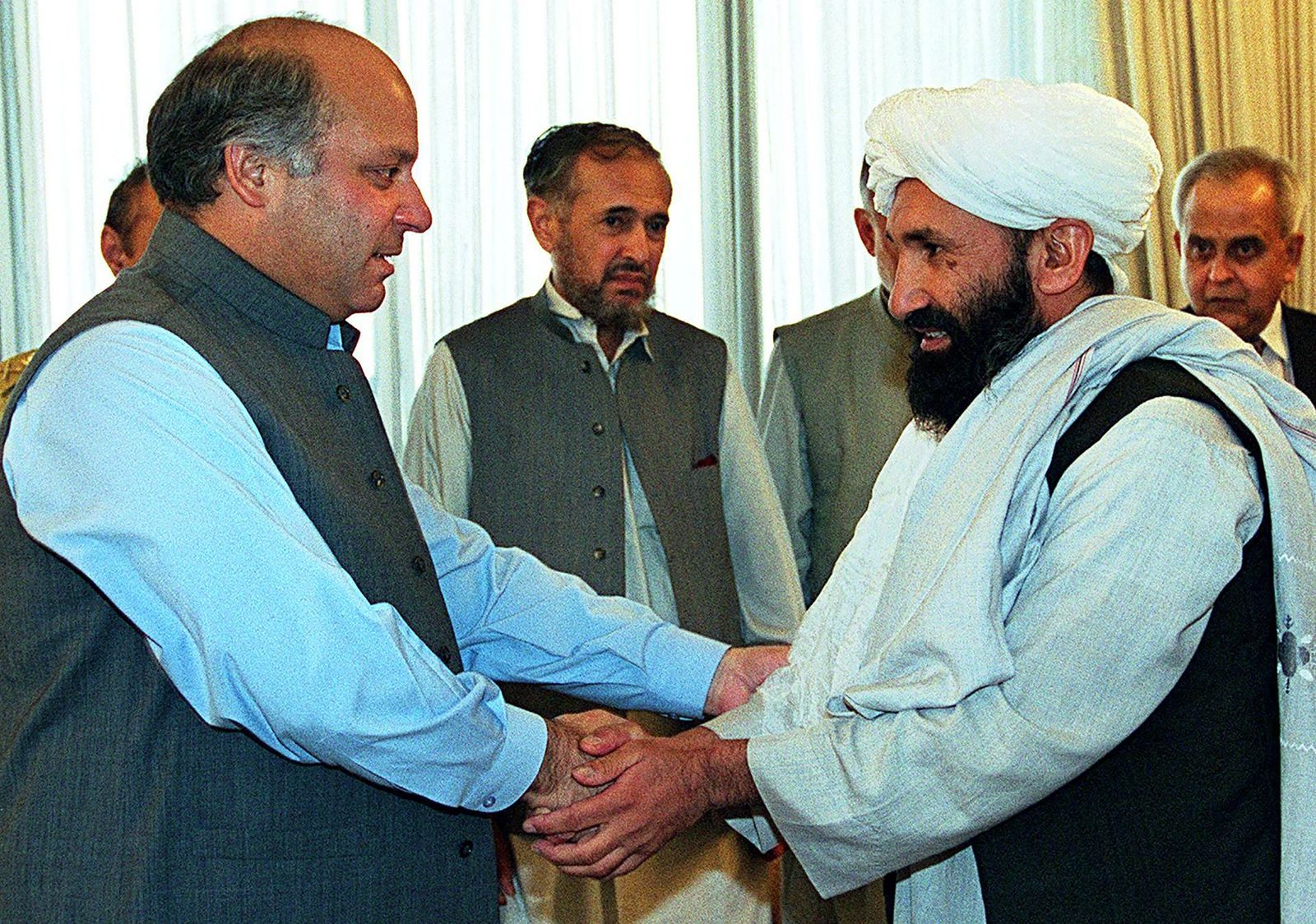 (FILES) In this file photo taken on August 26, 1999 Pakistani Prime Minister Nawaz Sharif receives Afghan Foreign Minister Mullah Mohammad Hassan Akhund (R) in Islamabad. - The Taliban announced Mullah Mohammad Hasan Akhund as the leader of their new government in Afghanistan on September 7, 2021. (Photo by SAEED KHAN / AFP) - AFP