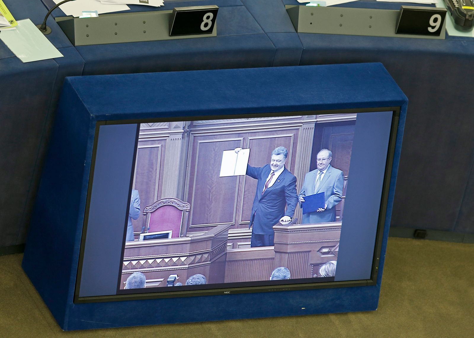 Ukraine's President Poroshenko is seen on a tv monitor as displays a signed landmark association agreement with the European Union during a live video conference between Kiev and Strasbourg, at the European Parliament in Strasbourg - REUTERS