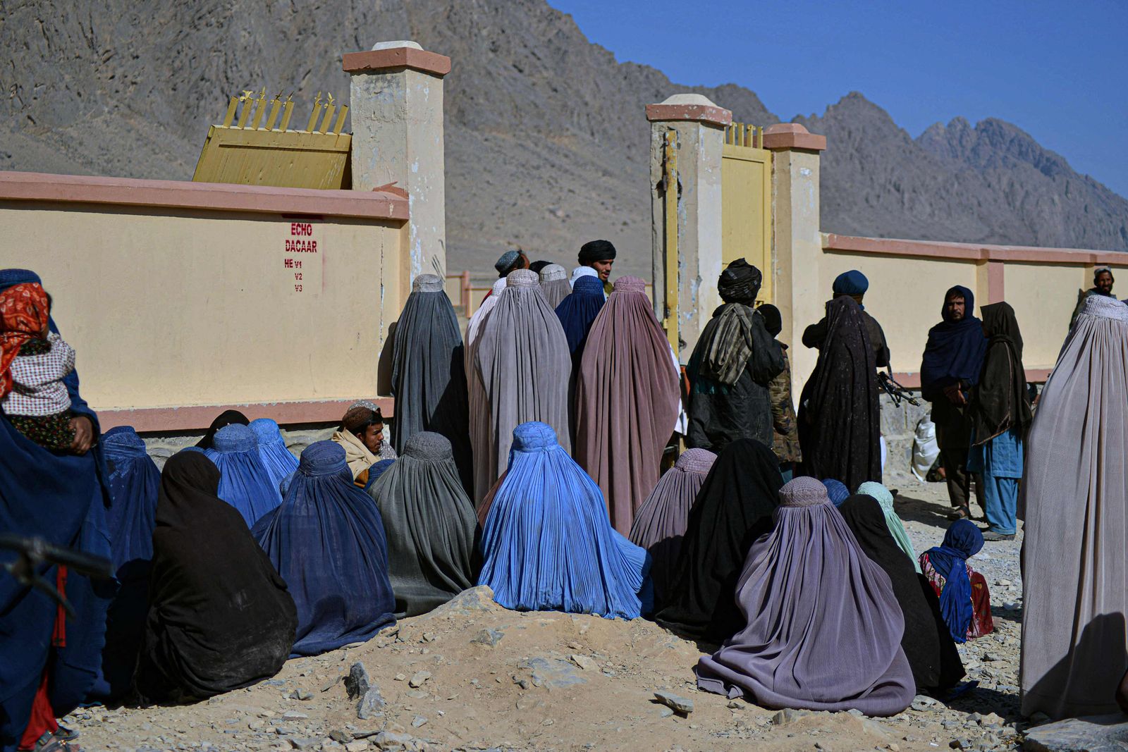 (FILES) In this file photo taken on December 15, 2021 people wait to collect food aid distributed by the Red Cross in Kandahar. - The United Nations said on January 11 it needed $5 billion in aid for Afghanistan in 2022 to avert a humanitarian catastrophe and offer the ravaged country a future after 40 years of suffering. (Photo by Javed TANVEER / AFP) - AFP