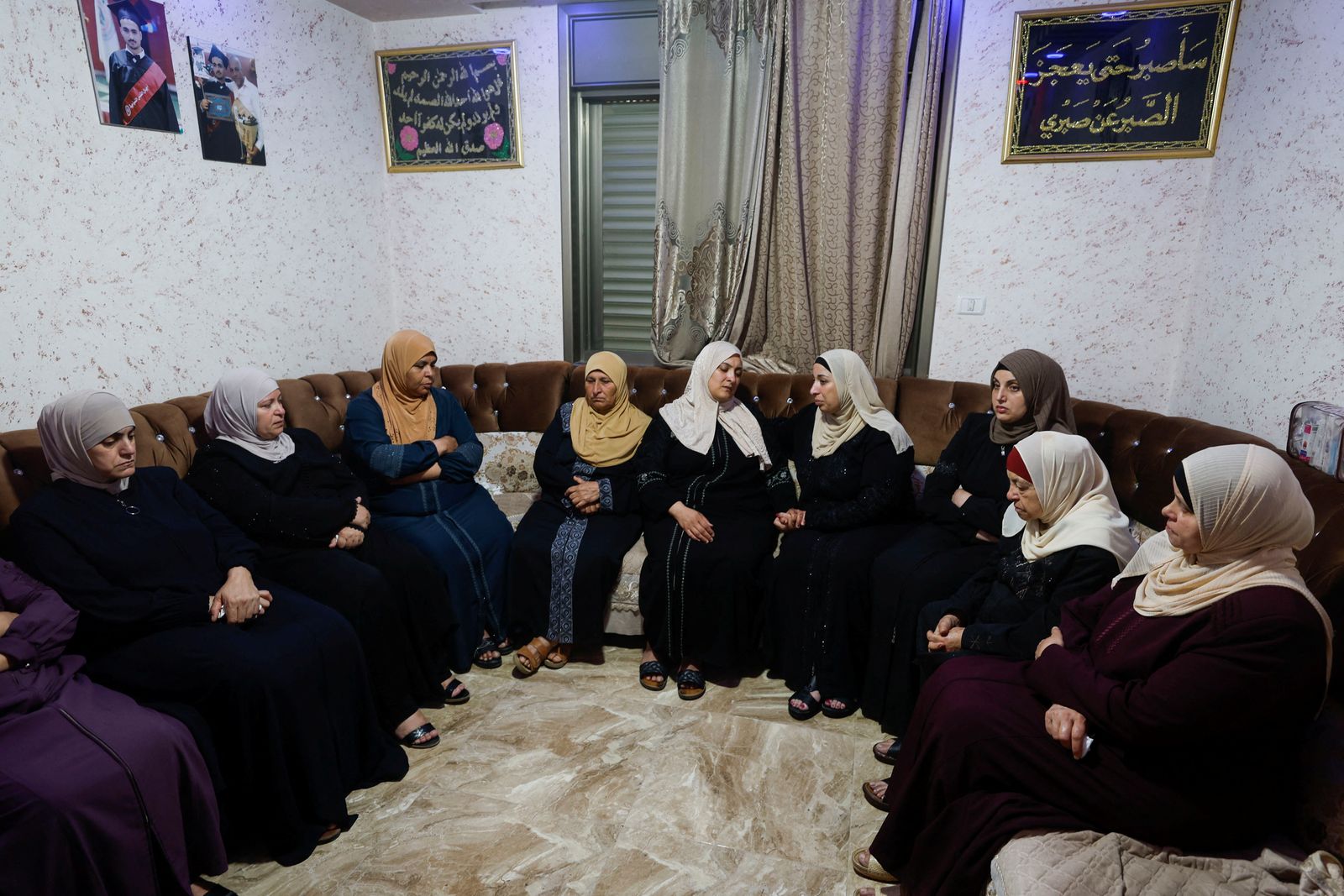 أقارب الفلسطيني محمد الشهام، الذي قتلته القوات الإسرائيلية خلال مداهمة، يتجمعون في كفر عقب بالضفة الغربية. 15 أغسطس 2022 - REUTERS