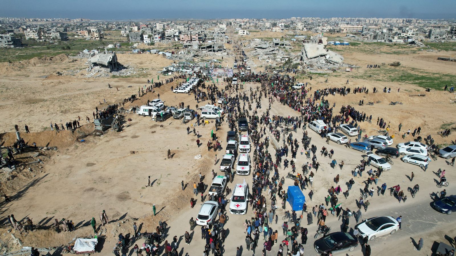 A drone view shows Palestinians gathering near Red Cross vehicles on the day Palestinian Hamas and Islamic Jihad militants release hostages held in Gaza since the deadly October 7, 2023 attack, as part of a ceasefire and a hostages-prisoners swap deal between Hamas and Israel in Khan Younis, in the southern Gaza Strip, February 15, 2025. REUTERS/Stringer     TPX IMAGES OF THE DAY" width="380" height="214